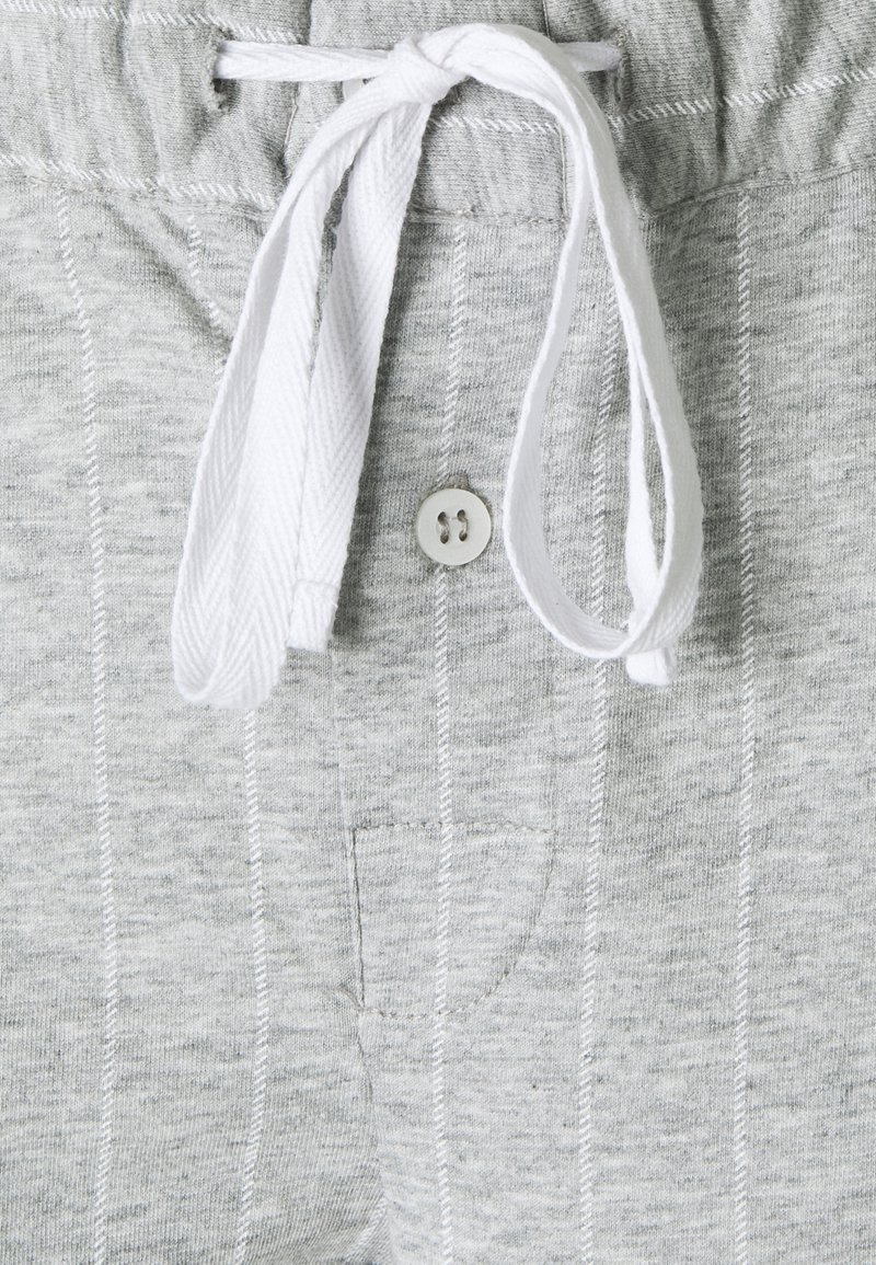 Grau Sweatpants aus weichem Material, mit einer weißen Kordel, vertikalen Streifen und einer kleinen Tasche auf der Vorderseite.