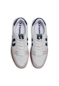 Białe trampki z zielonymi paskami i granatowymi akcentami. Posiadają cholewkę ze skóry, sznurowanie oraz gumową podeszwę.