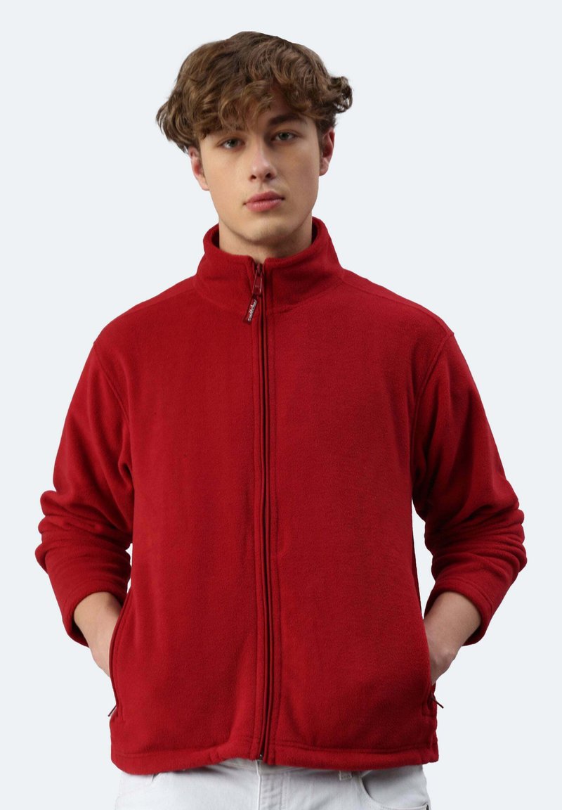 Giacca in pile rossa con colletto alto e chiusura con zip frontale. Maniche lunghe con polsini a coste. Presenta tasche laterali e una texture morbida.