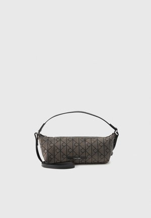 Rectangular brown Calvin Klein handbag with black diagonal circle pattern, black adjustable shoulder strap, and zip closure on top.