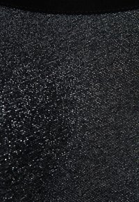 Svart tyg med en glänsande, texturerad yta, som har en metallisk lyster och fina, glittrande trådar genom hela.