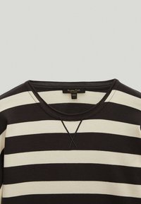 Maglione a righe nere e crema con collo a giro, caratterizzato da un tessuto textured e un dettaglio ricamato incrociato sul colletto.