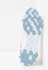 Löparskosula med vit bas och texturerad blå yttersula, cirkulära mönster och märkning. Snygg övergång från sula till ovandel.