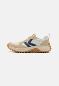 Beżowe i białe sneakersy z granatowymi akcentami, wykonane z zamszu i skóry, z teksturowaną gumową podeszwą, zaokrąglonym kształtem i sznurowanym designem.