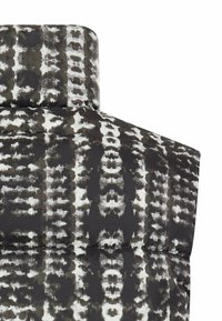 Pufferjack met een hoge kraag, geborduurd ontwerp en een zwart-wit dierenprintpatroon met een gladde, glanzende textuur.