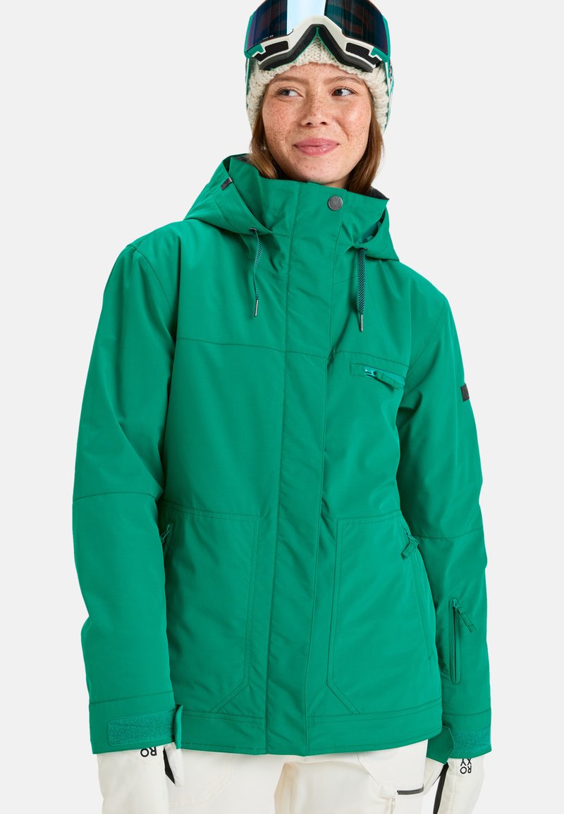 Groene waterdichte jas met een capuchon, voorzien van voor- en zijzakken, een ritsvak op de borst, verstelbare manchetten en zwarte accenten.