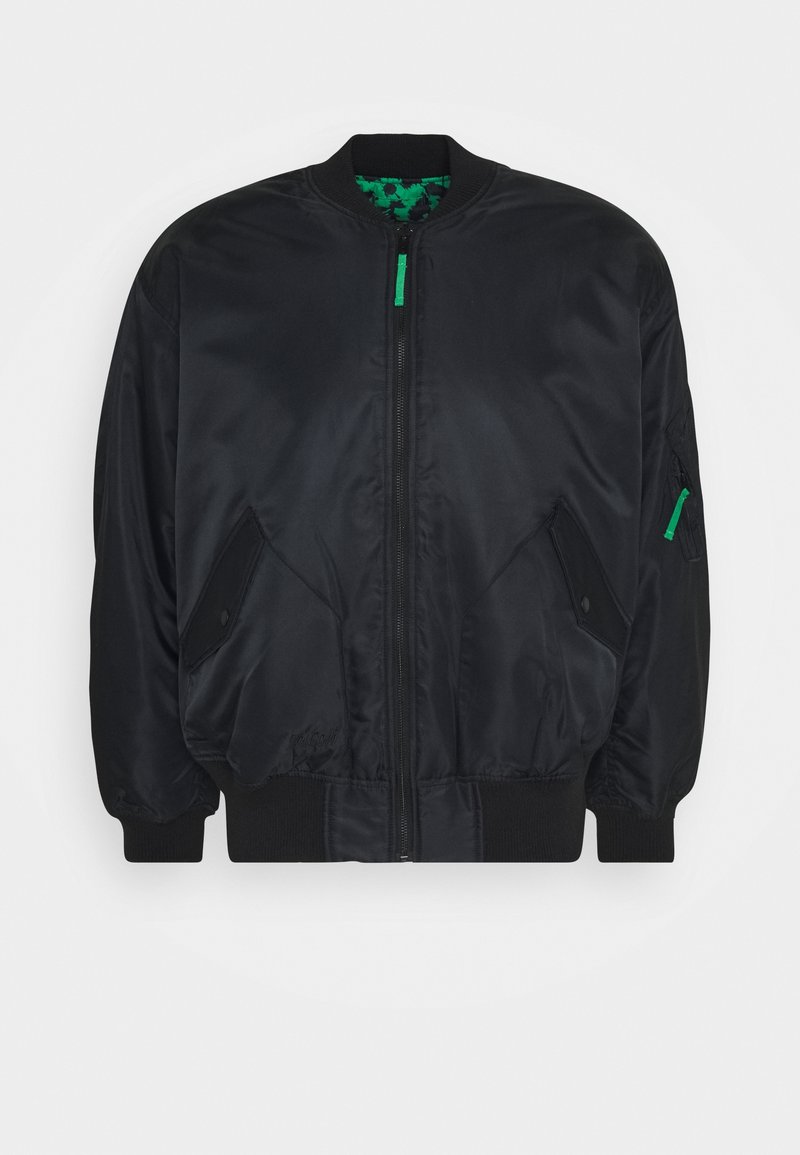 Veste bomber noire avec une finition satinée lisse, poignets côtelés, fermeture éclair à l'avant, poches latérales, et une doublure verte à motifs.