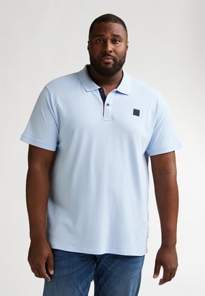 Polo azzurro chiaro in cotone. Presenta una patta con tre bottoni, un colletto contrastante blu navy e una piccola patch con logo sul petto.
