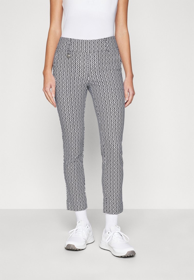 Patterned trousers in black and white, fitted design with a smooth texture, ankle-length cut, and a small pocket detail.