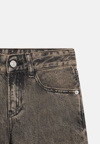 Melnas denima bikses ar nolietotu apdari, piecu kabatu dizainu un metāla pogu aizdari. Teksturēta auduma gluda virsma.