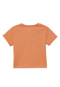 Koszulka z krótkim rękawem, okrągłym dekoltem, w jasnopomarańczowym kolorze, wykonana z bawełnianego materiału. Posiada prosty design, bez grafik i wzorów na plecach.