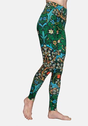 Groene leggings met een bloemenpatroon met blauwe, oranje en witte accenten. Het materiaal lijkt rekbaar met een aansluitend ontwerp.