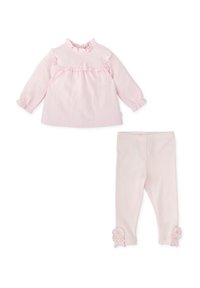 Top de punto rosa con mangas largas y cuello rizado, combinado con leggings a juego que presentan botones en forma de flor en el tobillo.