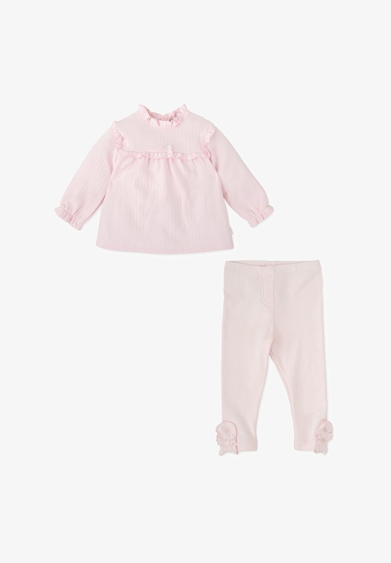 Top de punto rosa con mangas largas y cuello rizado, combinado con leggings a juego que presentan botones en forma de flor en el tobillo.