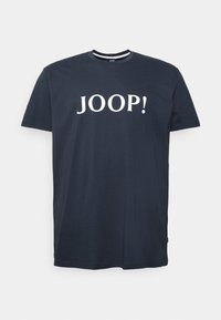 Camiseta de algodón azul marino de manga corta y cuello redondo. Presenta el texto blanco "JOOP!" de manera destacada en el frente.