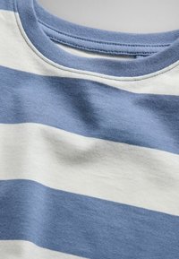 Close-up of a soft cotton shirt neckline with horizontal stripes in light blue and white.