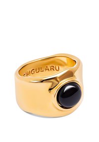 Bague en or avec une surface lisse et polie, mettant en valeur une pierre noire ronde sertie dans une monture proéminente. Gravure à l'intérieur : "SINGULARU."