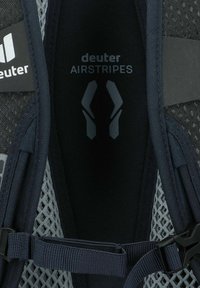 Zaino in rete nero e grigio con spallacci regolabili, caratterizzato dal logo "deuter AIRSTRIPES" e dettagli di design minimalisti.