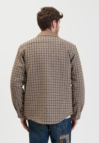 Bruine en beige geblokte jas van textuurstof, met een kraag, lange mouwen en knoopmanchetten. Achteraanzicht weergegeven.