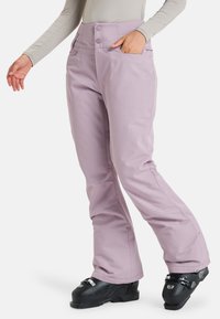 Lichtpaarse skibroek met een hoge taille, twee voorzakken en een gestroomlijnd ontwerp, gecombineerd met zwarte skibotten.