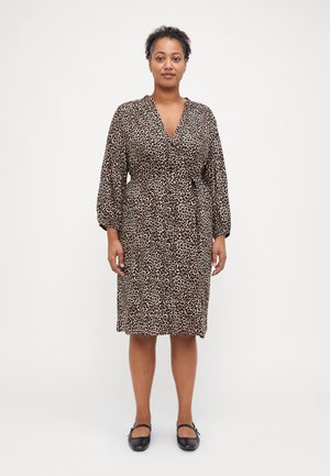 Klänning med leopardmönster i lätt material, knälång med omlottdesign, V-ringning och långa puffärmar. Matchad med svarta platta skor.