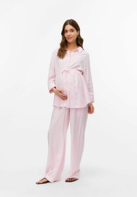 Completo loungewear a righe rosa, composto da una camicia con bottoni e pantaloni a gamba larga con cordoncino in vita. Tessuto morbido e vestibilità rilassata.