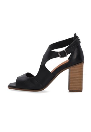 Sort åben tå højhælet sandal med træ-klods hæl og justerbar ankelrem med sølvspænde, sidevisning på hvid baggrund.
