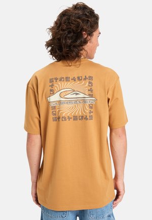 Short-sleeve, amber-colored t-shirt made of cotton. Features large graphic print on back with curved lines and text in contrasting colors.