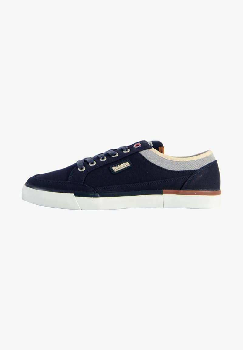 Zapatillas de lona navy con suela de goma blanca, diseño con cordones, acentos beige alrededor del cuello y un pequeño logo en el lateral.