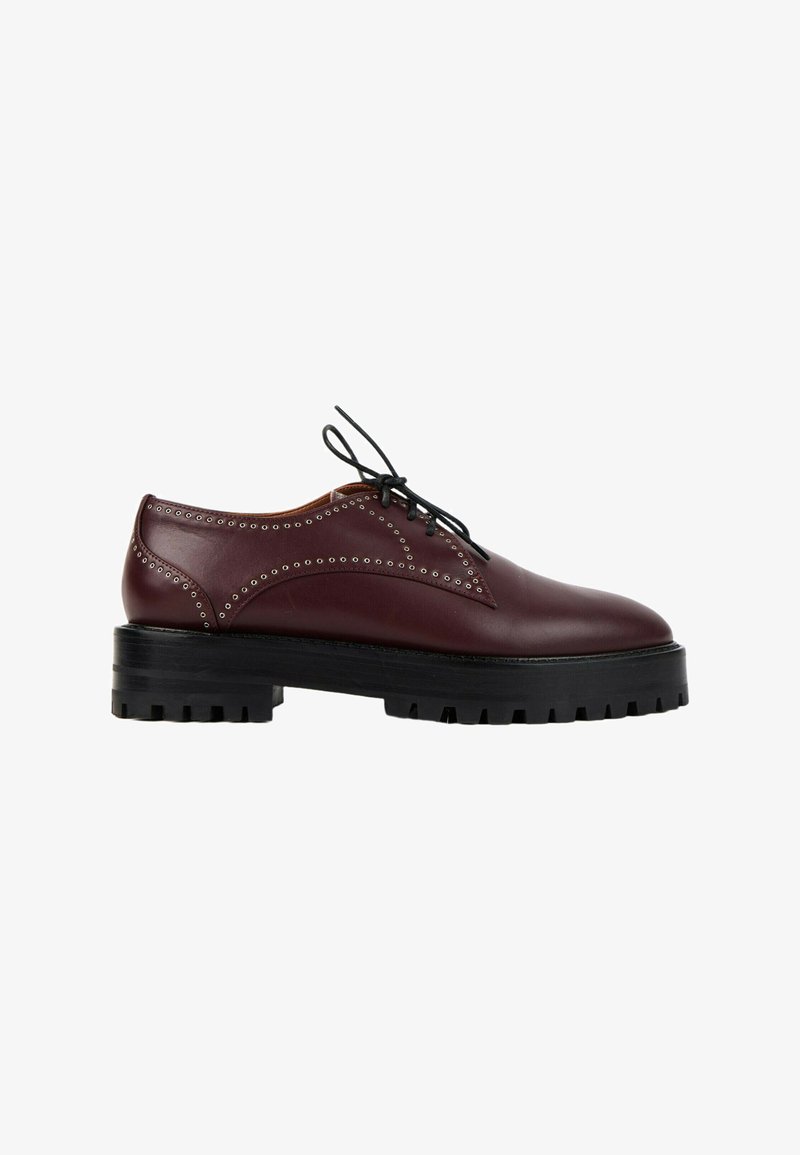 Chaussure montante en cuir marron foncé avec perforations décoratives et semelle épaisse noire crantée, vue de côté extérieur.