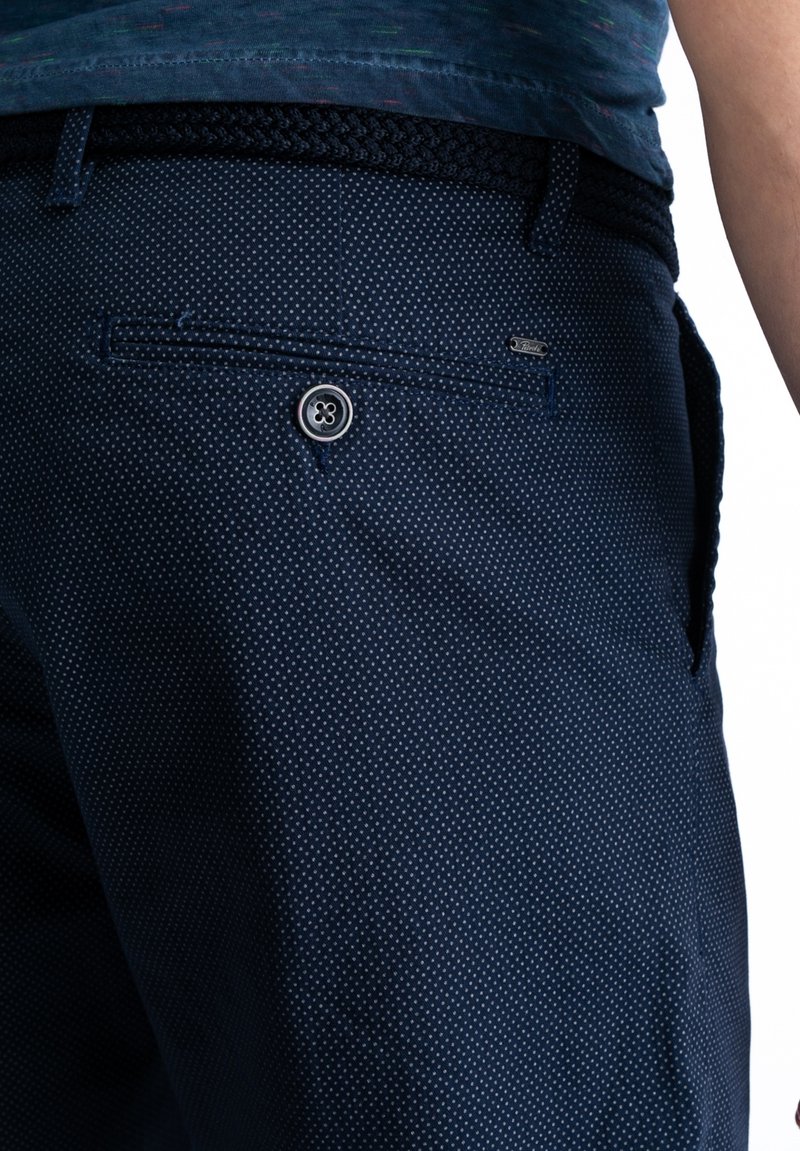 Navy blue trousers with a small polka dot pattern. Features a button closure and a braided belt, made from a textured fabric.