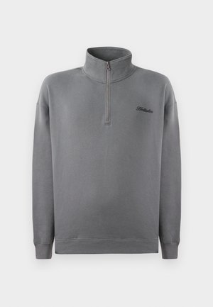 Hallilise krae ja ribatud varrukate ning äärega hall fliispullover, millel on rinnal väike must logo. Pehme tekstuur, mugav lõige.