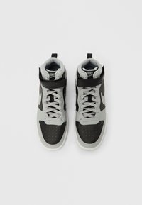 Aukšti sportiniai batai su juodos odos išore, pilkais zomšos akcentais, perforuotu pirštu, pilkais raišteliais ir dirželiu per kulkšnį.