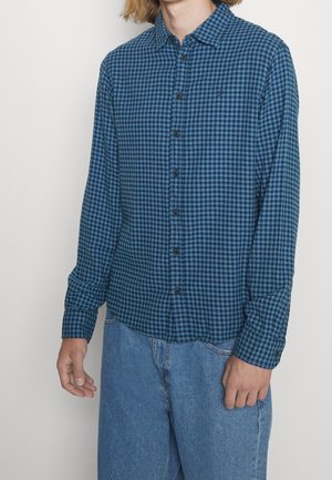 Blau- und schwarz kariertes Hemd mit langen Ärmeln und klassischem Kragen, ausgestattet mit schwarzen Knöpfen und einem weichen, strukturierten Stoff.
