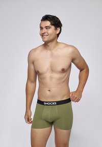 Pánské olivově zelené boxerky s černým elastickým pasem, na kterém je značka "SNOCKS". Hladký materiál s přiléhavým střihem.