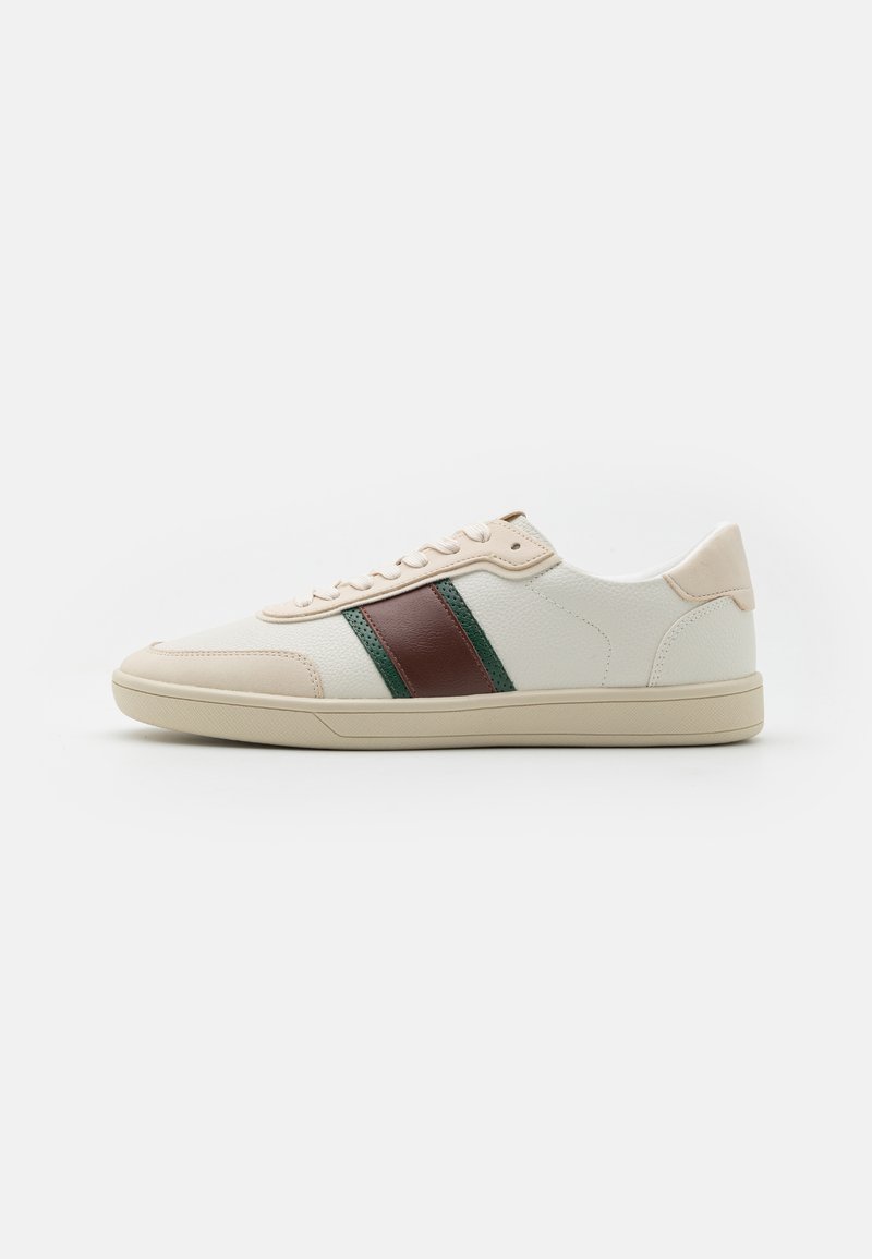 Sneaker bianco a basso profilo con suola e lacci beige, caratterizzato da strisce in pelle marrone scuro e verde sui lati, visto dal lato esterno.