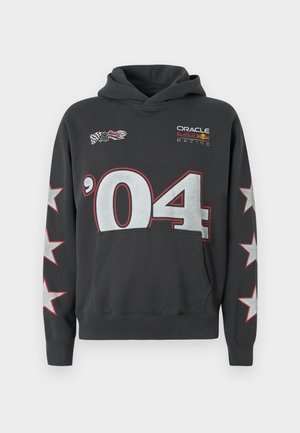 Juodas džemperis su užtraukiamu gobtuvu, priekinė kišenė, didelis sidabrinis '04' dizainas ir balti žvaigždės ant rankovių. Logotipai ant krūtinės.