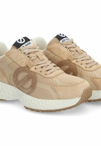 Zapatillas de ante y malla beige con una suela texturizada, que cuentan con un logo circular en el lateral y un collar acolchado para mayor comodidad.