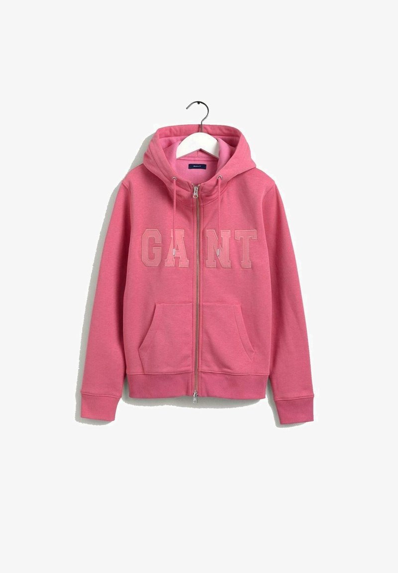 Veste à capuche rose zippée avec poches avant, capuche à cordon et logo "GANT" inscrit sur la poitrine, présentée sur un cintre blanc.