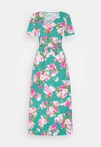 Vestido floral em teal com mangas curtas, decote em V, corpete justo e cintura marcada com um cinto amarrado. Padrões grandes de flores rosas e brancas por toda a peça.