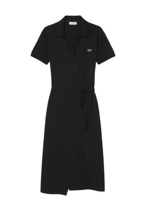 Vestido negro de manga corta con cuello, cinturón ajustable en la cintura y pequeño logo de cocodrilo verde en el pecho.