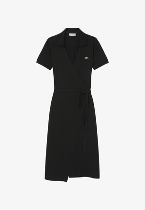 Vestido negro de manga corta con cuello, cinturón ajustable en la cintura y pequeño logo de cocodrilo verde en el pecho.