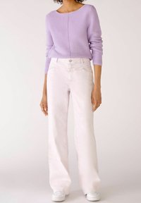 Lavender knit sweater with a boat neckline and long sleeves, paired with light pink wide-leg jeans and white sneakers. Smooth texture throughout.