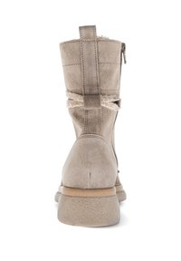 Beige suède laars met een achterrits en een decoratieve band; textiel voering zichtbaar aan de bovenrand; rubberen zool.