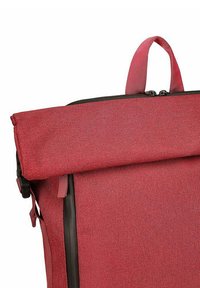 Červený batoh s rolovacím vrchem, vyrobený z texturované látky, s černým zipem a vrchním uchycením pro nošení. Disponuje elegantním designem bez dalších ozdob.