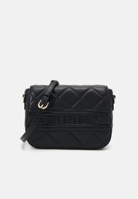 Borsa a tracolla in pelle nera trapuntata con tracolla regolabile, caratterizzata da logo impresso e strisce orizzontali in accento. Dettagli in hardware dorato presenti.