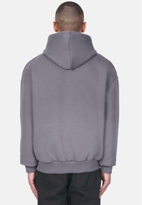 Grijze hoodie met een trekkoordcapuchon, oversized ontwerp, ribgebreide manchetten en boord, met een gladde textuur en relaxte pasvorm.