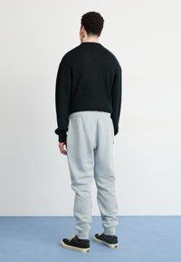 Nike Sportswear JOGGER   - Treniņtērpa apakšdaļas - light pumice