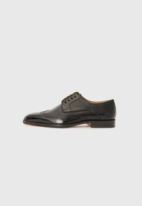 Sorte skinn oxford-sko med spisset tå, perforert brogue-detaljering og et elegant design. Har lav hæl og snøring.