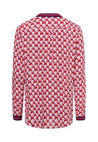 B shirt a maniche lunghe rosso e bianco con un motivo geometrico. I polsini presentano una striscia blu navy e il tessuto appare liscio e leggero.